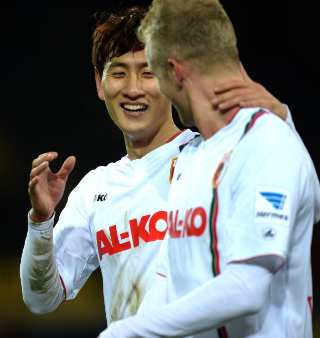 FC Augsburg’s Ji Dong-won celebrates his goal with teammate Andre Hahn on Saturday.   AFP-Yonhap