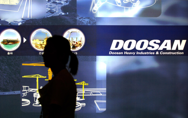 An employee walks past a sign at Doosan Heavy Industries & Construction’s plant in Changwon, South Gyeongsang Province.   Bloomberg