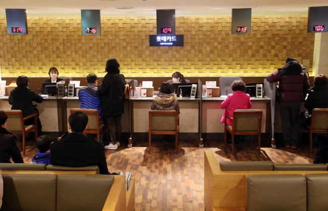 Customers line up on Sunday to renew or cancel their credit cards at Lotte Department Store in the Jung-gu district of Seoul in the aftermath of a massive credit card data breach.   Yonhap