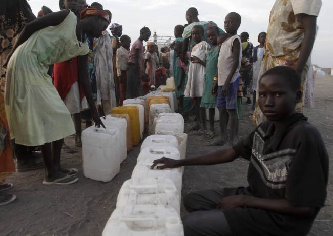South Sudanese refugees wait to fill jerrycans with water at a camp run by the Sudanese Red Crescent on Sunday in the western part of Sudan’s White Nile state, about 30 kilometers from South Sudan, after fleeing battles between rebel and government forces.   AFP-Yonhap