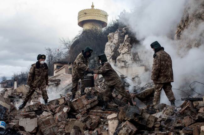 This picture taken on Jan. 12 shows rescuers sifting through the wreckage of damaged houses in the ancient Tibetan town of Gyalthang, in Shangri-La, Yunnan province, China, after a fire flattened two-thirds of the town’s old center.   AFP-Yonhap
