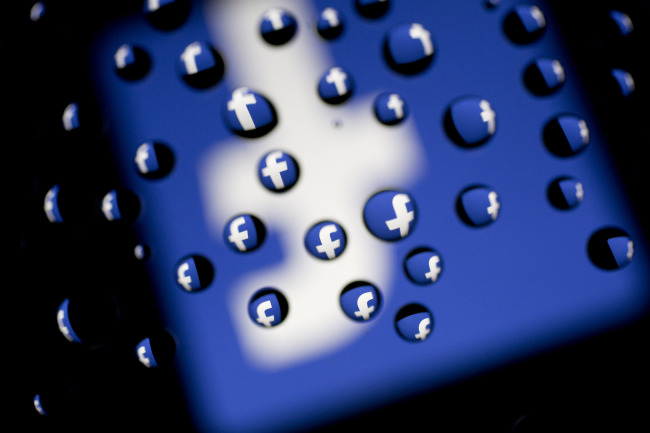 The Facebook Inc. logo is displayed on an Apple Inc. iPad Air past water droplets in Washington, D.C., Monday.   Bloomberg