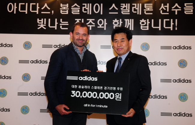 아디다스 코리아 지온 암스트롱 대표이사가 대한봅슬레이스켈레톤 경기연맹 강신성 회장에게 기부금을 전달 하고 있다. [사진제공=아디다스]
