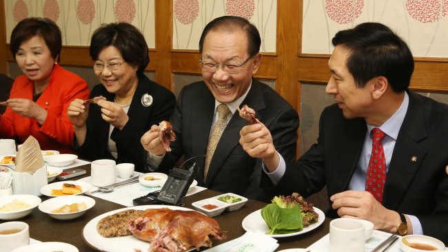 Rep. Hwang Woo-yea (second from right), chairman of the ruling Saenuri Party, and a group of party leaders eat baked duck at a restaurant in Yeouido, western Seoul, on Wednesday. Lee Gil-dong/The Korea Herald