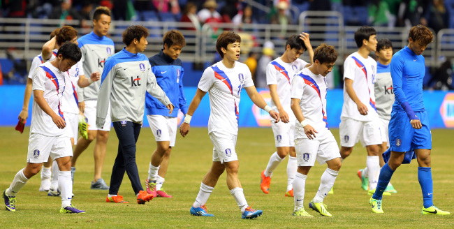 Korean soccer players walk off the pitch after losing to Mexico in San Antonio, Texas on Thursday. Yonhap
