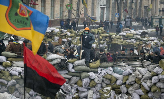 Protesters stand on a barricade in central Kiev on Saturday.   AP-Yonhap