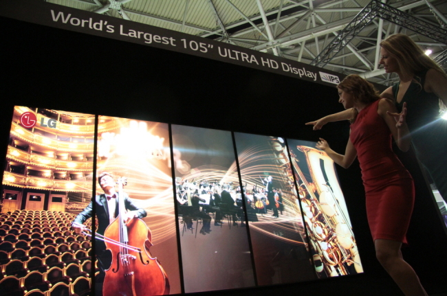 Models pose with LG Electronics’ 105-inch curved ultra HD TV displayed at Integrated Systems Europe, a commercial display trade show held in Amsterdam from Tuesday to Thursday.   LG Electronics