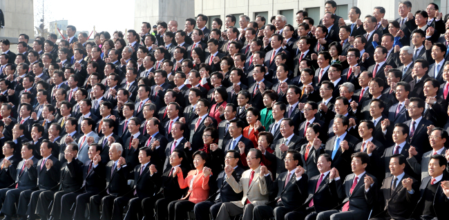 Lawmakers hold hands for a group photograph after the opening session of the extraordinary session at the National Assembly on Monday. The 26-day session is expected to be fraught with interparty discord over legislation and other ongoing issues.   Lee Gil-dong/The Korea Herald