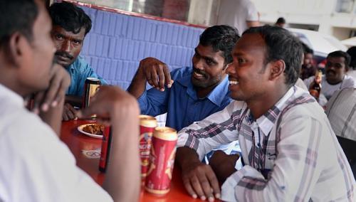 (Clockwise from left) Workers Murugan Ponnusamy, 30; Mani Munusamy, 26; Velu Arumugam, 31; and Kuberan Mani, 25, having a beer last Sunday at Spice Box restaurant at about 4 p.m. The three brothers and their uncle, Mr. Munusamy, still meet every Sunday but do so in the afternoons instead of at night.    The Straits Times