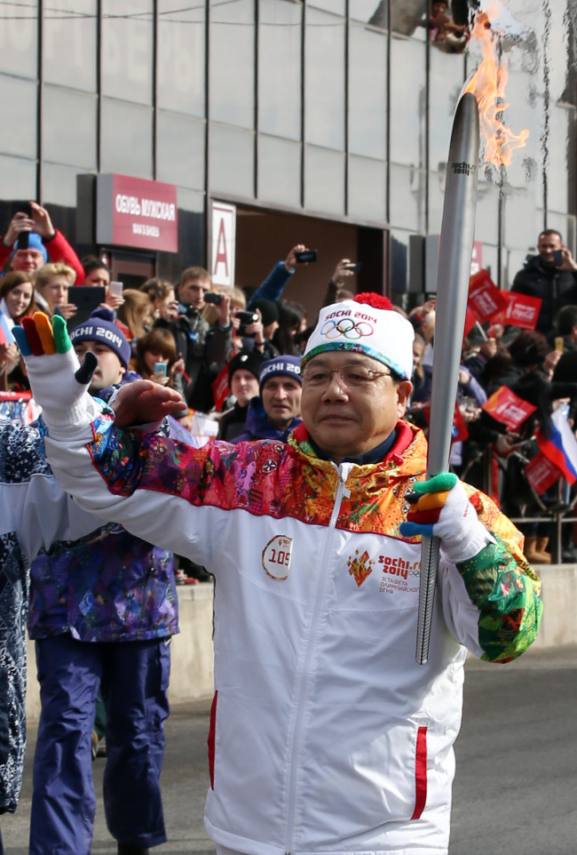 Kim Jin-sun, the chief organizer of the 2018 Winter Olympics, carries the Olympic torch.   Yonhap