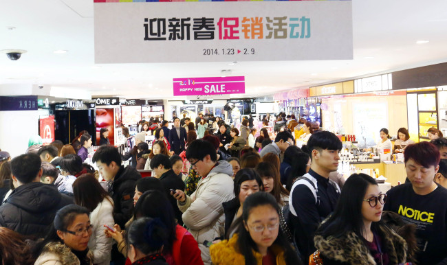 Foreign tourists shop at a duty-free store in Seoul.   Yonhap