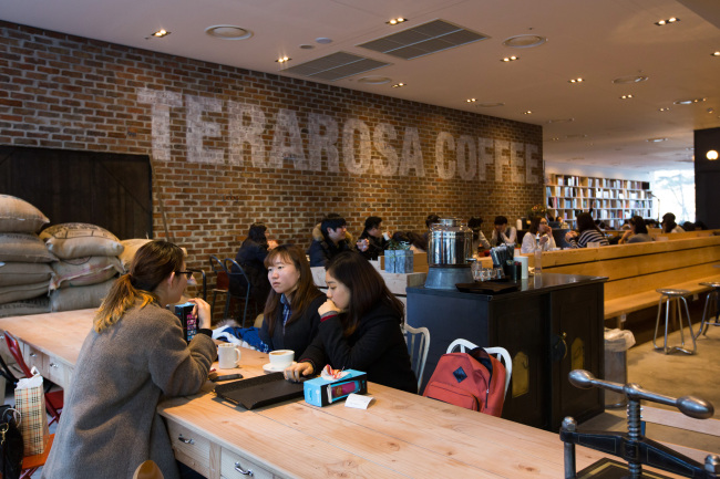 Customers chat and drink coffee at the Terarosa Coffee shop in Seoul.   Bloomberg
