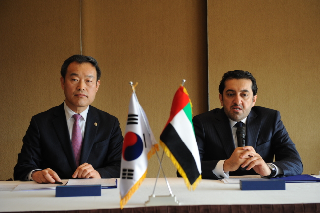 Korea Intellectual Property Office Commissioner Kim Young-min (left) and UAE Vice Economy Minister Abdul Aziz speak during a news conference after signing a memorandum of understanding on a state business alliance in Seoul on Friday.   KIPO