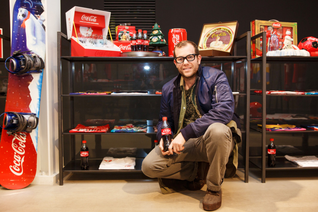 Designer Dr. Romanelli poses with his “Coca-Cola by DRX” collection at the Kasina fashion store in southern Seoul on Friday. The designer, famous for reconstructing vintage items into new artwork, released a range of garments, ornaments and accessories inspired by the Coca-Cola logo.   Coca-Cola Korea
