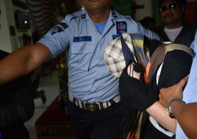 Australian drug trafficker Schapelle Corby is escorted by police and prison officials at the prosecutor’s office after she was freed from prison on parole on the Indonesian resort island of Bali on Sunday.   AFP-Yonhap
