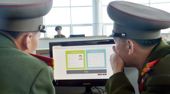 North Korean guards check the ID of a South Korean worker at the customs and immigration office of the Gaeseong industrial complex.   Joint Press Corps