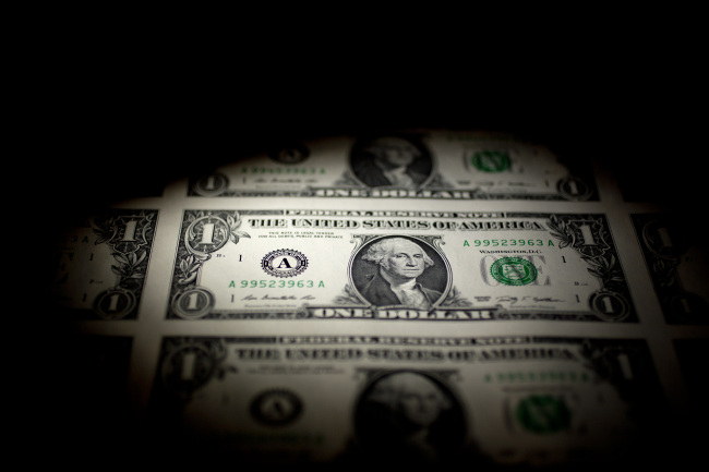 A sheet of uncut $1 bills is arranged for a photograph in Washington, D.C.   Bloomberg