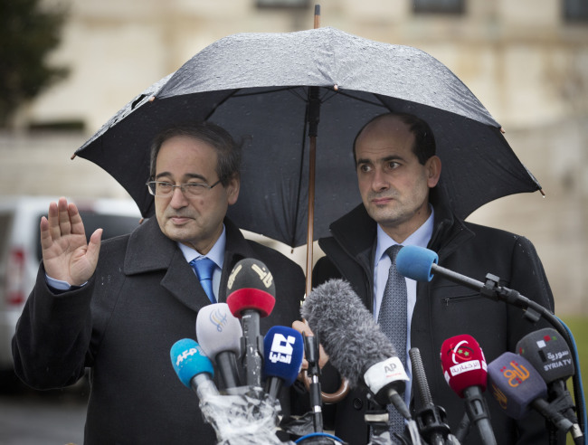 Syrian Deputy Foreign Minister Faisal al-Muqdad (left) gestures as he arrives with an aide for a press briefing at the United Nations headquarters in Geneva, Switzerland, Monday.   AP-Yonhap