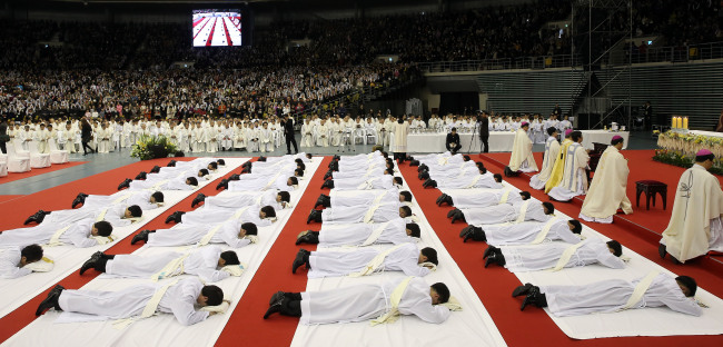 Priests prostrate themselves during an ordination ceremony in Seoul on Feb. 7.   Yonhap