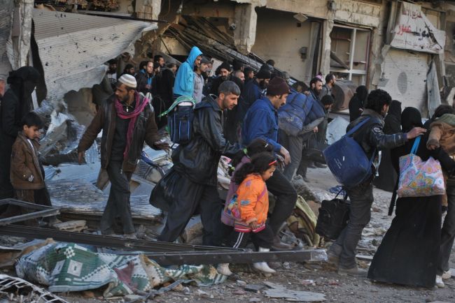 Syrian civilians are evacuated during a humanitarian operation in the Syrian city of Homs on Monday.   AFP-Yonhap