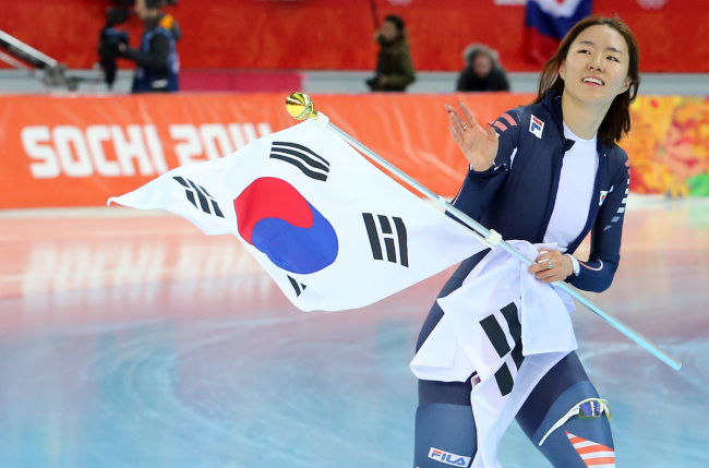 이상화(스케이트선수/서울시청)
Speed skater Lee Sang-hwa was labeled “Usain Bolt of the ice track” on Tuesday as she successfully defended her Olympic title for the women’s 500 meters to earn Korea’s first gold in Sochi.
Lee Sang-hwa waves the national flag after winning the women’s 500-meter speedskating race at the Adler Arena Skating Center during the 2014 Winter Olympics in Sochi, Russia, Tuesday.   Yonhap