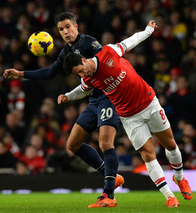 Man United’s Robin van Persie (left) and Arsenal’s Mikel Arteta vie for the ball on Wednesday.   AFP-Yonhap