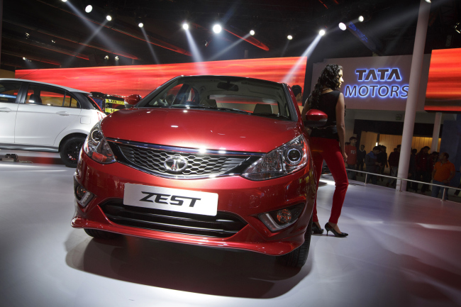A model poses with a Tata Motors Zest vehicle during the 12th Auto Expo 2014 in Noida, India, on Feb. 7.   Bloomberg