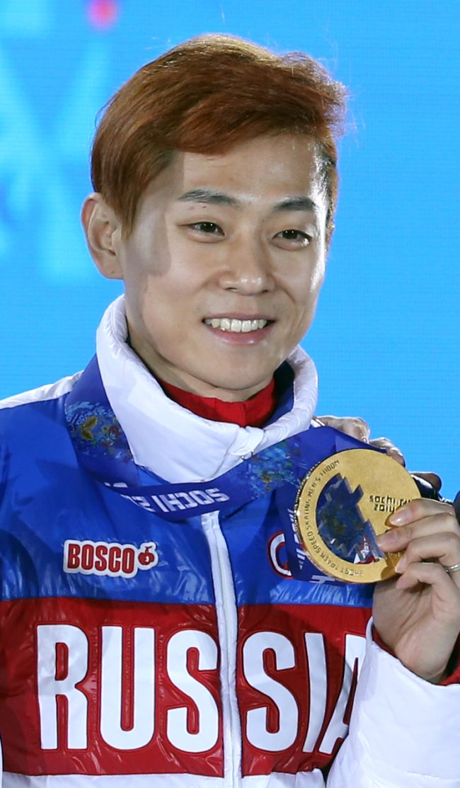 Korean-born Viktor Ahn of Russia holds out the gold medal after winning the 1,000m short track speed skating in Sochi on Saturday. (Yonhap)