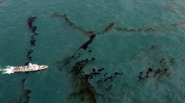 A vessel sails in the waters off Busan hit by an oil spill Sunday.   Yonhap