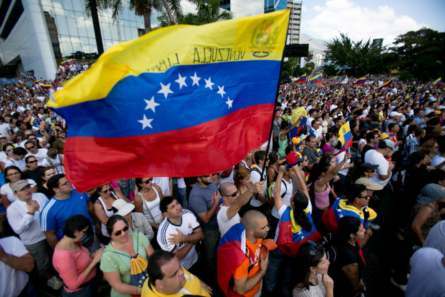 A demonstrator waves the Venezuelan flag during a protest in Caracas on Sunday.   AP-Yonhap