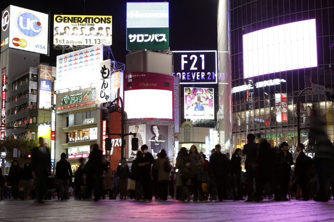 Pedestrians walk through a street in the Shibuya district of Tokyo.   Bloomberg