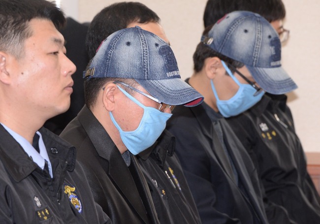 A Korea Credit Bureau employee surnamed Park (right), who allegedly stole personal data from credit card companies, and an ad agency official only identified as Cho (center), who purchased the stolen data, attend a hearing in a parliamentary probe by the National Policy Committee of the National Assembly in Seoul on Tuesday. The two suspects were arrested after a massive data leak concerning some 20 million clients at KB Kookmin Card, Lotte Card and NH NongHyup Card last month. Lee Gil-dong/The Korea Herald