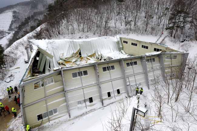 Police officers inspect a collapsed building at Manua Ocean Resort, Gyeongju, North Gyeongsang Province, Tuesday. The accident killed 10 and injured more than 100.   Yonhap