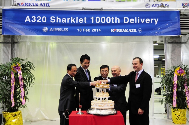 Korean Air executive vice president Cho Won-tae (second from left), Airbus executive vice president for programs Tom Williams (second from right) and other company executives attend a cake-cutting event celebrating the air carrier’s 1,000th delivery of the Airbus-designed “sharklet,” a specialized winglet on the A320, at the Korean firm’s Busan tech center Tuesday.   Korean Air