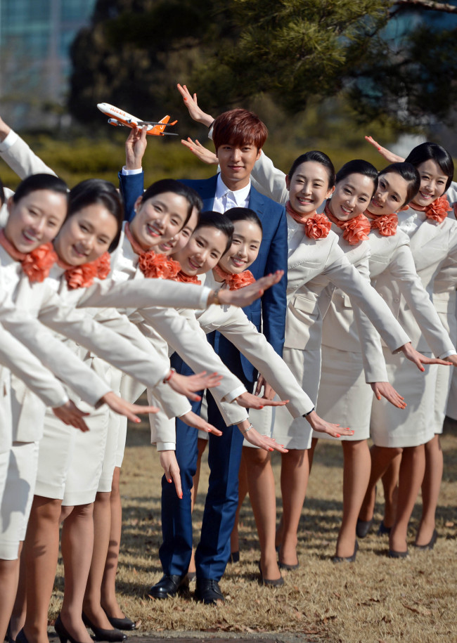 Actor Lee Min-ho, selected as a model for Jeju Air, takes a commemorative photograph with stewardesses at Gimpo Airport on Wednesday.   Lee Sang-sub/The Korea Herald