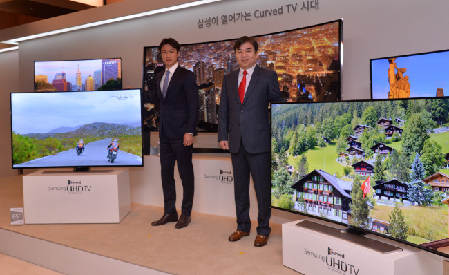 삼성전자는 20일 한국 시장을 통해 세계 최초로 곡면 초고해상도(울트라HDㆍUHD) TV를 출시했다.  ‘삼성전자 커브드 UHD TV’ 광고 모델인 홍명보(왼쪽) 축구 국가대표팀 감독과 김현석 김현석 삼성전자 영상디스플레이사업부장(부사장)이 삼성전자의 곡면 UHD TV 신제품을 소개하고 있다.  이상섭 기자/babtong@heraldcorp.com