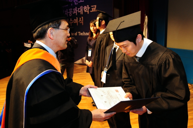 지난 20일 경기 화성 화성캠퍼스에서 열린 삼성전자공과대학교 학위수여식. 총장인 권오현(왼쪽) 삼성전자 부회장이 한 졸업생에게 졸업장을 건네며 축하하고 있다. [사진제공=삼성전자]