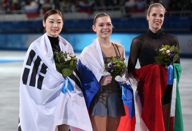 김연아(좌부터/스케이트선수),아델리나소트니코바(AdelinaSotnikova/스케이트선수),카롤리나코스트너(CarolinaKostner/스케이트선수)
Kim Yu-na said she was swamped with emotions when she realized she had been dethroned as Olympic champion despite a flawless performance in Sochi ― but admitted she was “relieved it was over.”
South Korea’s silver medalist Kim Yu-na (left), Russia’s gold medalist Adelina Sotnikova (center) and Italy’s bronze medalist Carolina Kostner pose with their national flags during the women’s figure skating flower ceremony at the Iceberg Skating Palace during the Winter Olympics in Sochi, Russia, Thursday.   Yonhap
South Korea’s silver medalist Kim Yu-na (left), Russia’s gold medalist Adelina Sotnikova (center) and Italy’s bronze medalist Carolina Kostner pose with their national flags during the women’s figure skating flower ceremony at the Iceberg Skating Palace during the Winter Olympics in Sochi, Russia, Thursday.   Yonhap