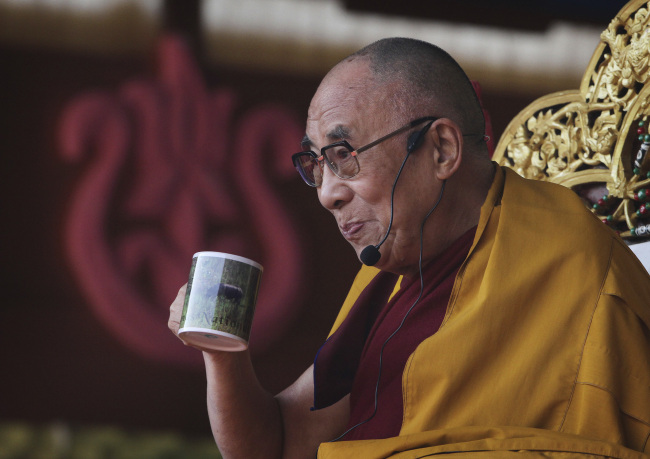 Tibetan spiritual leader the Dalai Lama sips tea during his sermons at a five-day festival of Tibet, in Gauhati, India, earlier this month.  AP