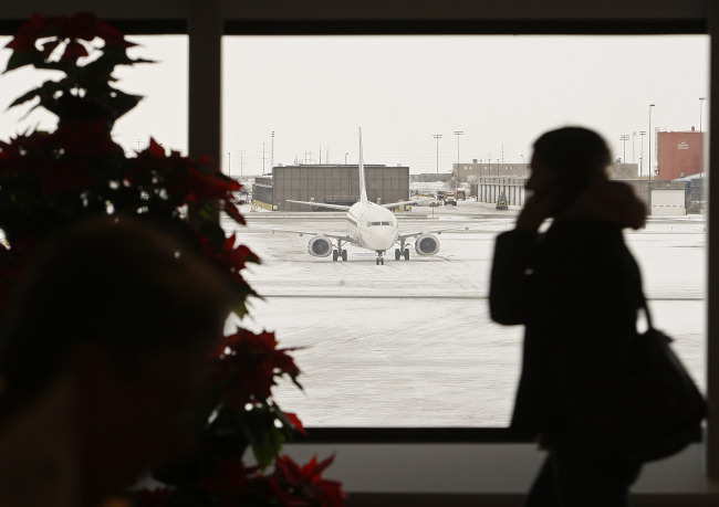 A passenger talks on her phone as she makers her way to her flight at Salt Lake City International Airport in Salt Lake City, Utah.   Bloomberg