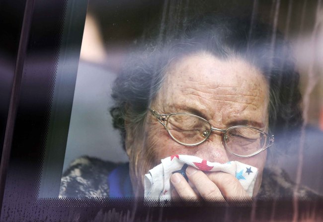 A South Korean woman weeps on a bus after tearfully bidding farewell to her North Korean relatives at the end of the first round of three-day reunions at Mount Geumgangsan on Saturday.   Joint Press Corps