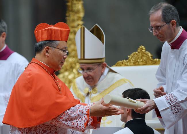 South Korean Andrew Yeom Soo-jung (left) receives official papers as he is appointed cardinal by Pope Francis during a consistory in St. Peter’s basilica at the Vatican on Saturday. AFP-Yonhap