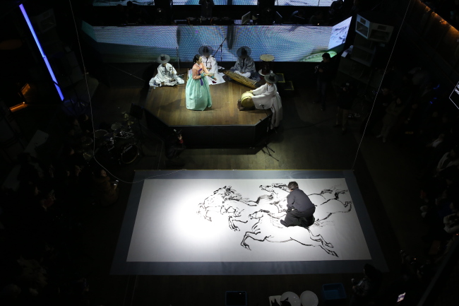 Artist Kim Mu-ho gives a painting performance at “Klang With Concert: Anticipation” on Feb. 20.   Shinhwa TGR