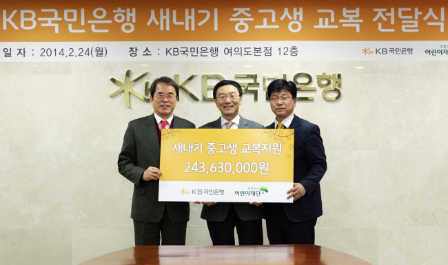 KB Kookmin Bank CEO Lee Kun-ho (center) poses with ChildFund Korea president Lee Je-hoon (left) and KB’s labor union leader Sung Nak-jo at the bank’s head office in Seoul on Monday, after donating some 240 million won ($223,000) raised by bank staff to provide school uniforms to underprivileged children.   KB Kookmin Bank