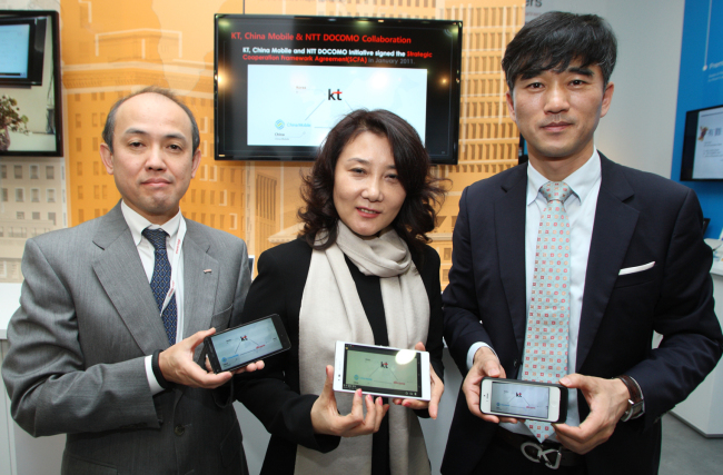 Officials from KT, China Mobile and NTT DoCoMo pose with their smartphones as they launch cross-border LTE roaming services at the WMC in Barcelona, Spain, Tuesday.   KT
