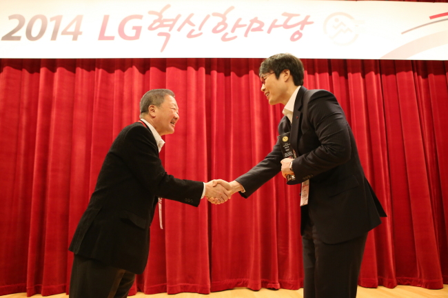 구본무(왼쪽) LG그룹 회장이 ‘일등LG상’을 수상한 LG유플러스 ‘100% LTE’팀 김유진 부장에게 상패를 수여한 뒤 악수하고 있다. [사진제공=LG그룹]