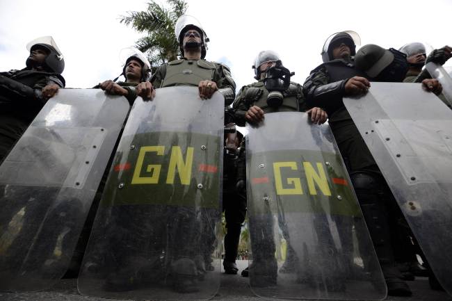 Members of the National Guard stand outside the Cuban Embassy during a protest against the government of Venezuelan President Nicolas Maduro in Caracas on Tuesday.   AFP-Yonhap