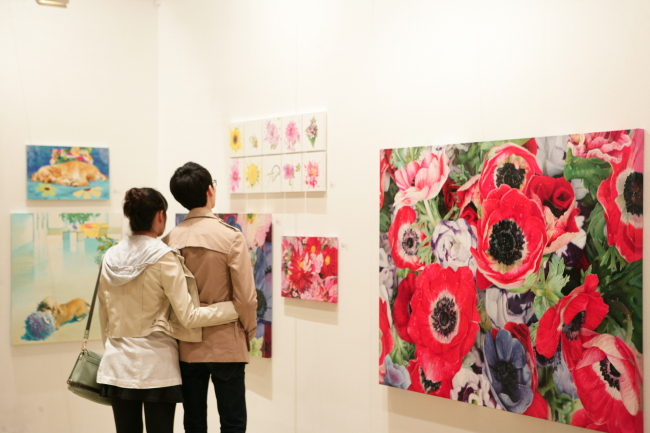Visitors look at art on display at the Korea Galleries Art Fair in 2013.   Korea Galleries Art Fair