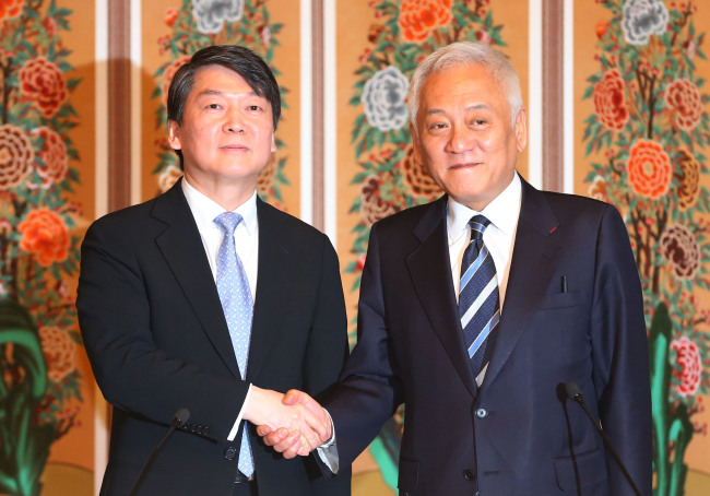 Kim Han-gil, head of main opposition Democratic Party, shakes hands with businessman-turned-politician Ahn Chul-soo upon vowing to create a new united coalition party ahead of the June 4 local elections. (Yonhap)