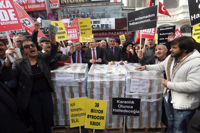 People stand next to stacks of fake euro notes during a demonstration against Turkey’s prime minister in Ankara on Saturday.   AFP-Yonhap